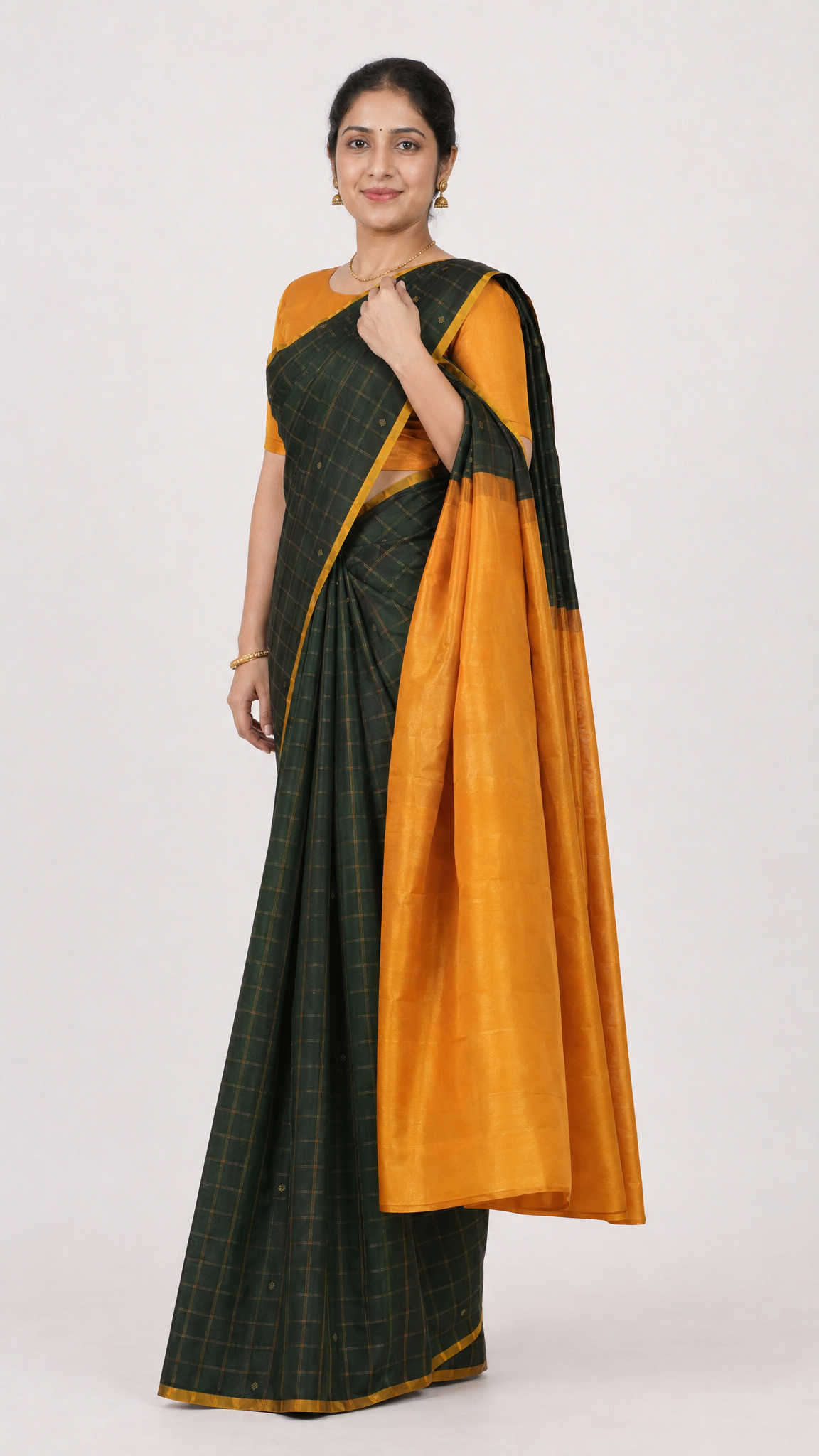 Green check silk saree with orange pallu and gold-toned border, draped over shoulder