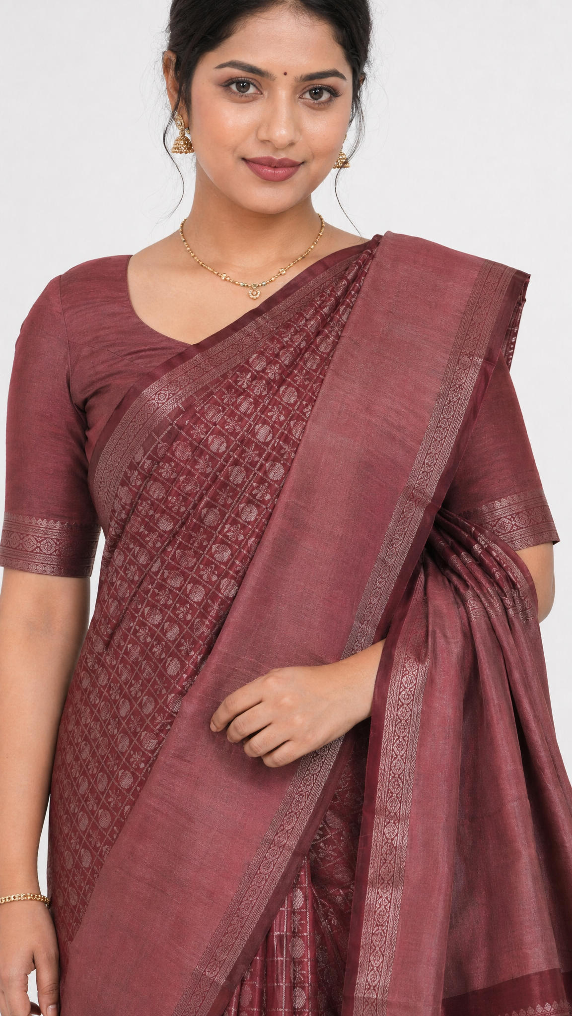 maroon silk saree close-up with textured weave and zari-like border on pallu