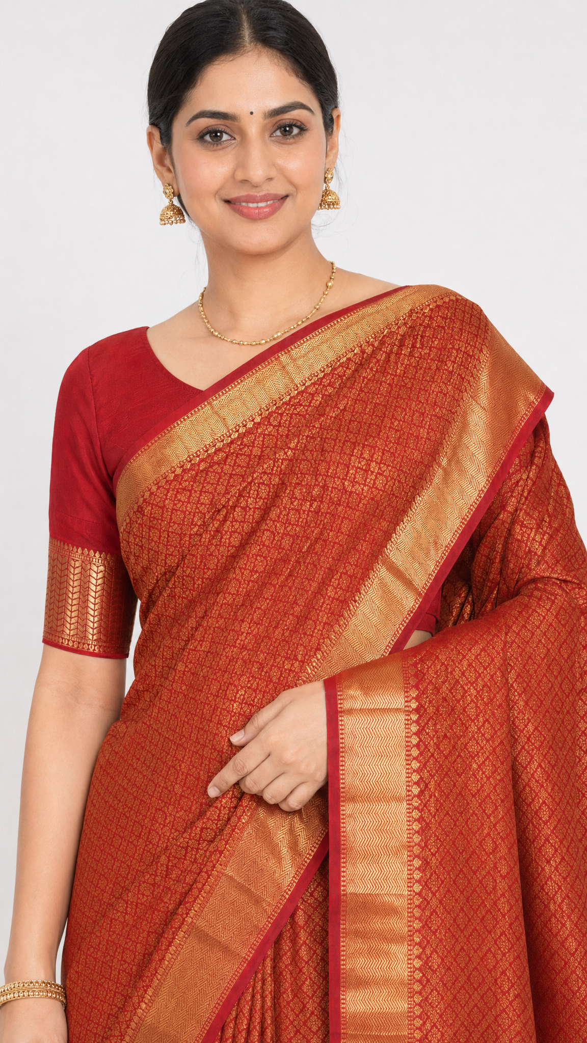 Red silk saree with ornate gold border and textured body; short sleeve blouse